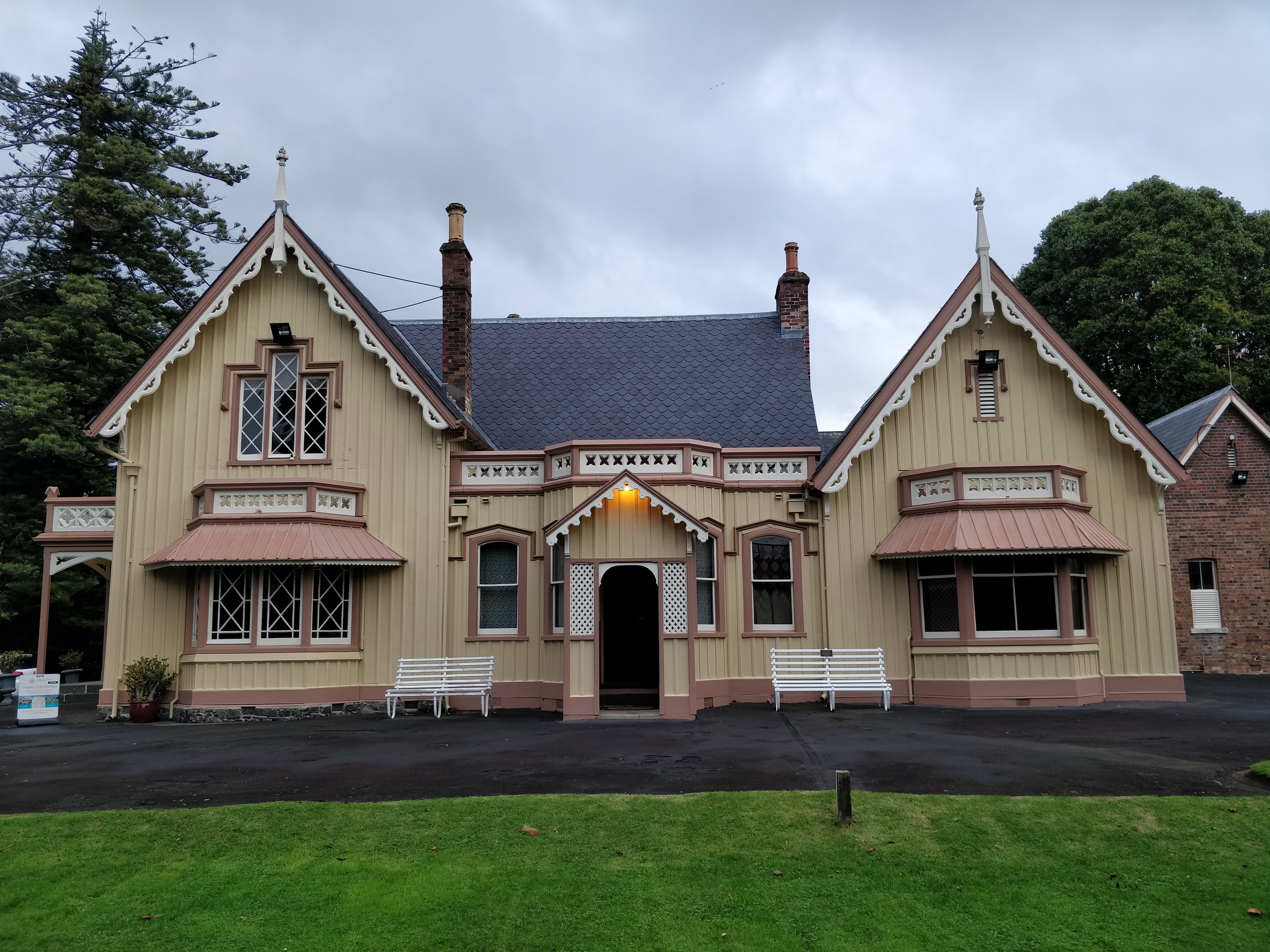 Ornate historic house with gabled roof, windows, and manicured grounds