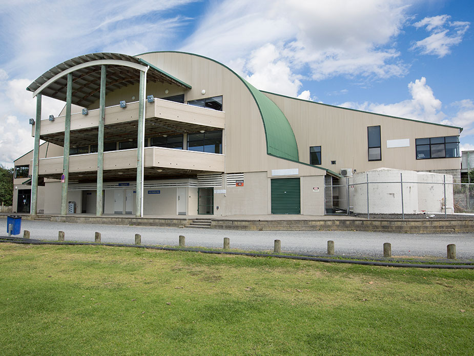 Two-storey arched metal roof building exterior with lawn in foreground