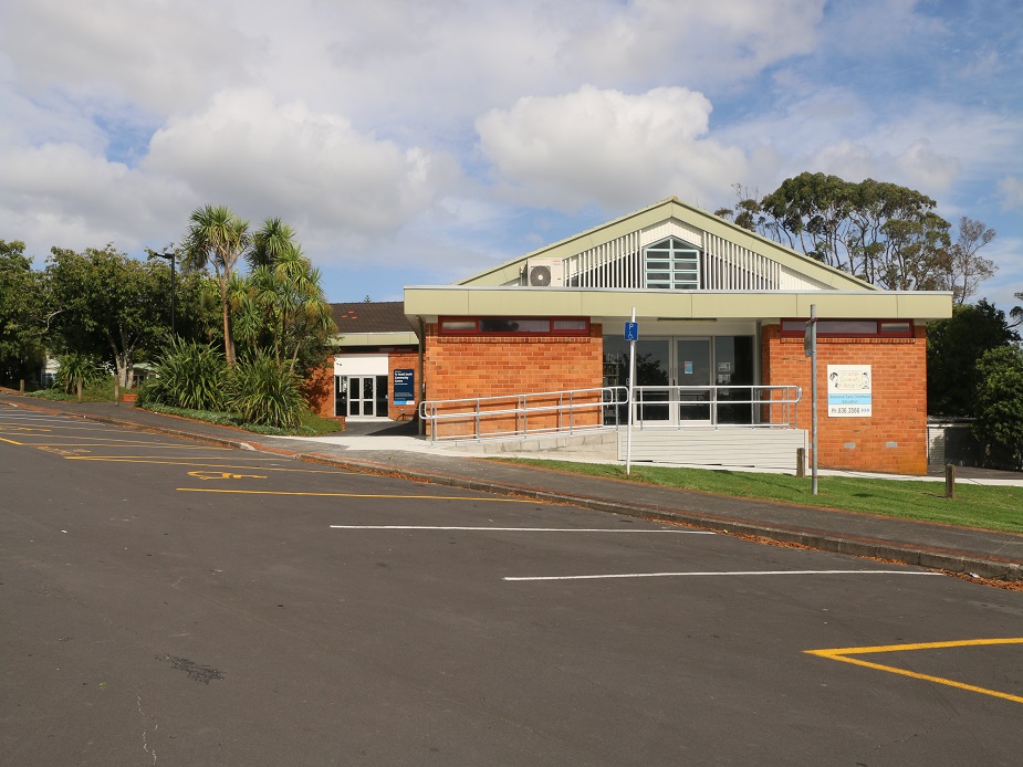 Single-storey brick building with car park in foreground and accessible ramp entry