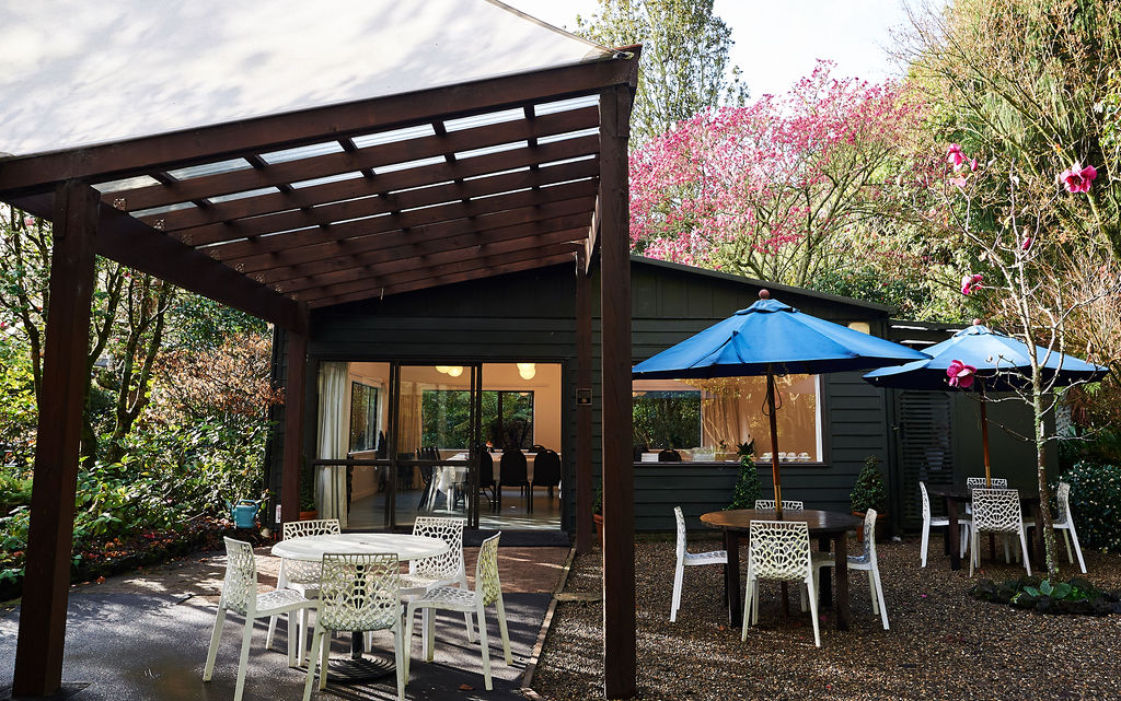 Timber-clad hall with long tables, globe pendant lights and vaulted ceiling