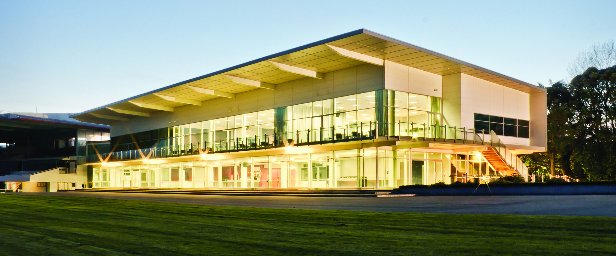 Large modern function centre building with full-length glazing, illuminated at dusk