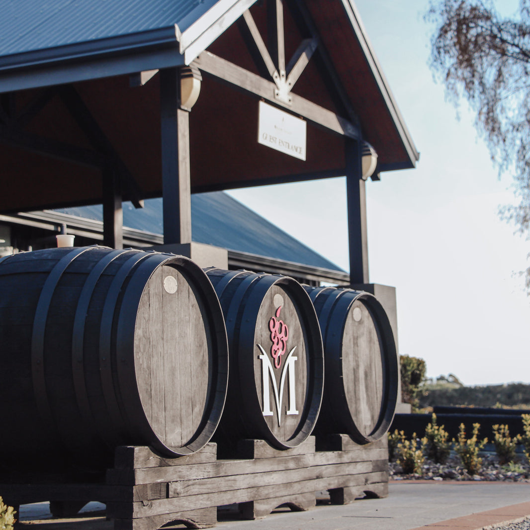 Winery entrance with large barrels and pavilion structure