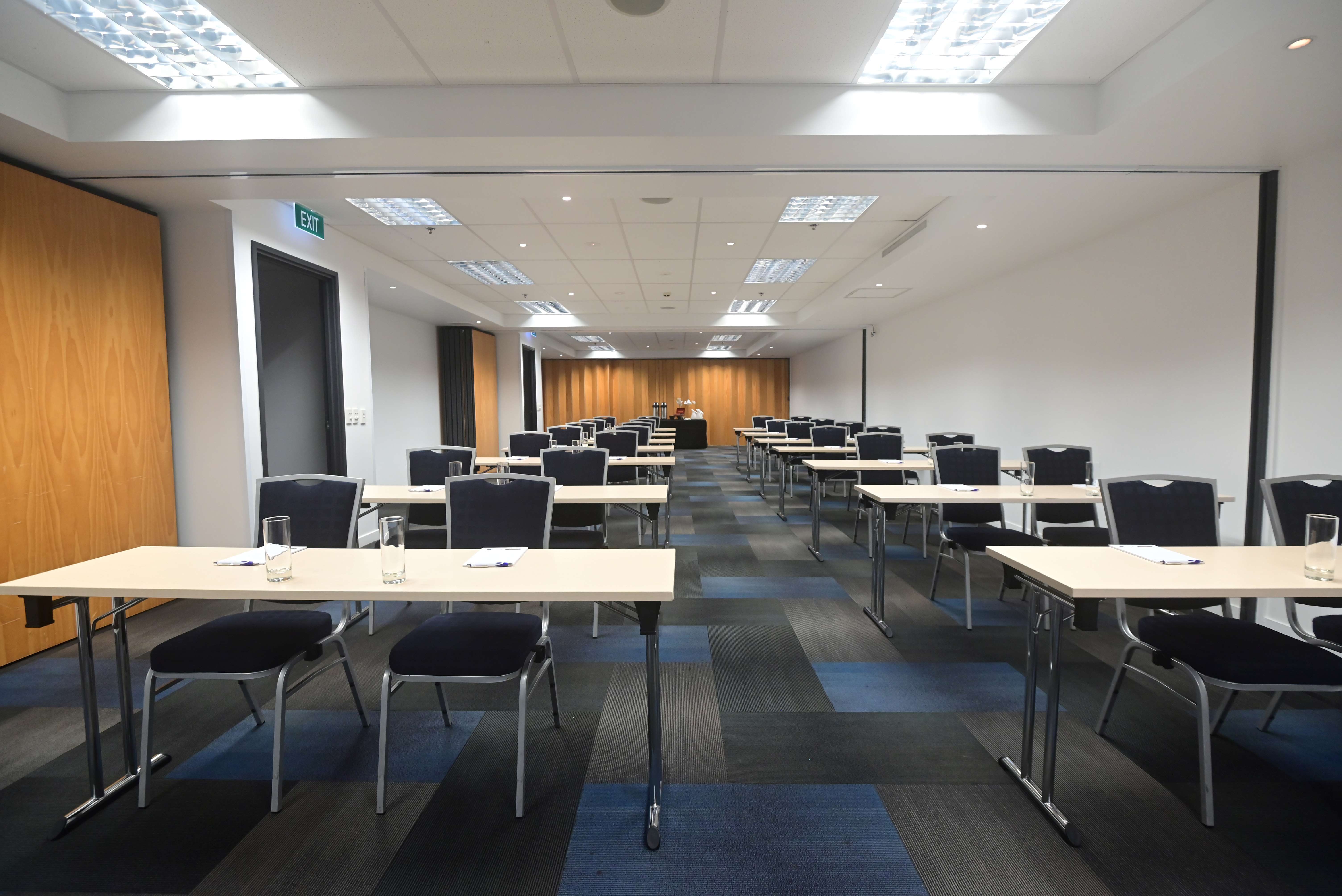 Conference room with classroom table rows and timber feature wall