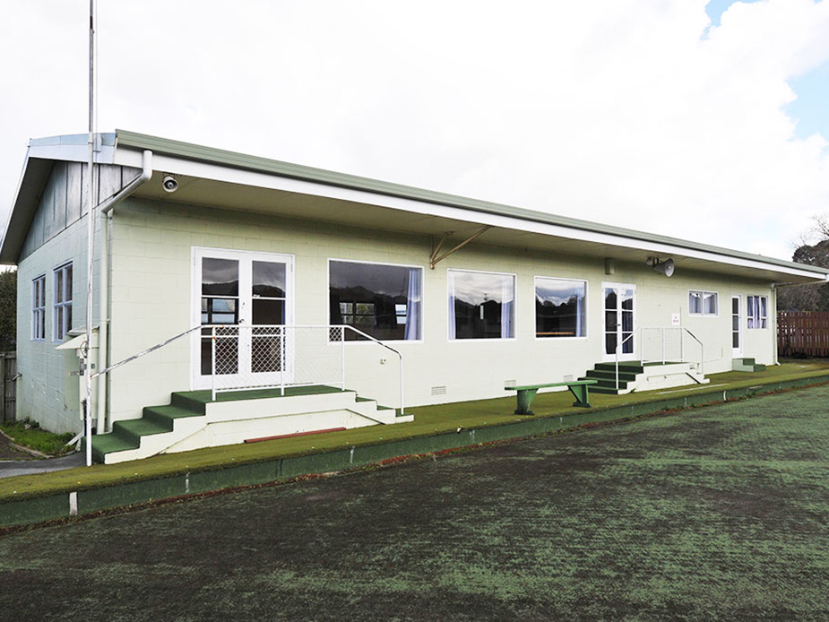 Single-storey hall building with green roof, verandah and outdoor steps