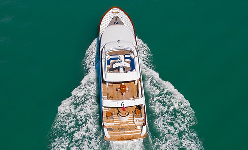 Aerial view of motor yacht underway in turquoise water