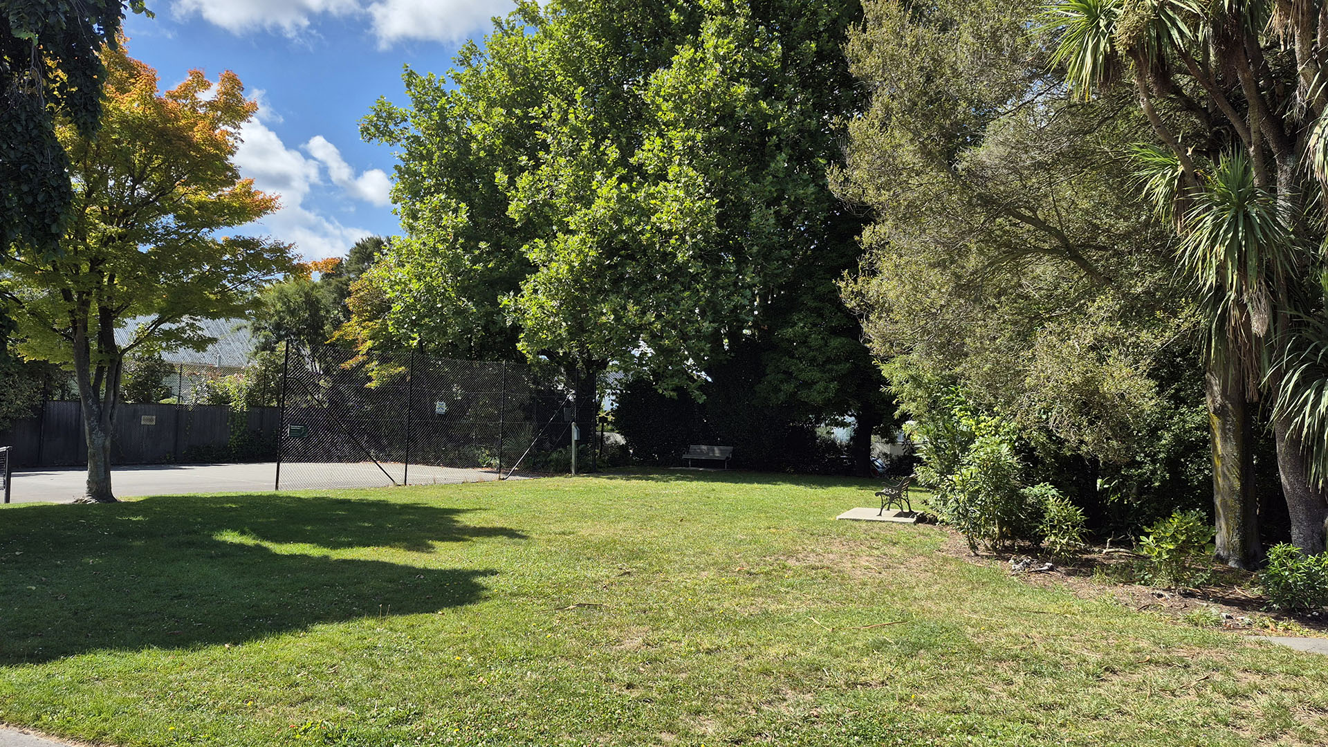 Open grassed reserve with trees and garden planting