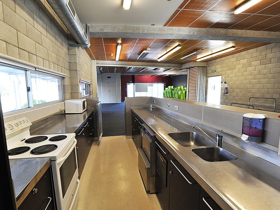 Commercial kitchen with stainless steel benches, stove and overhead extraction