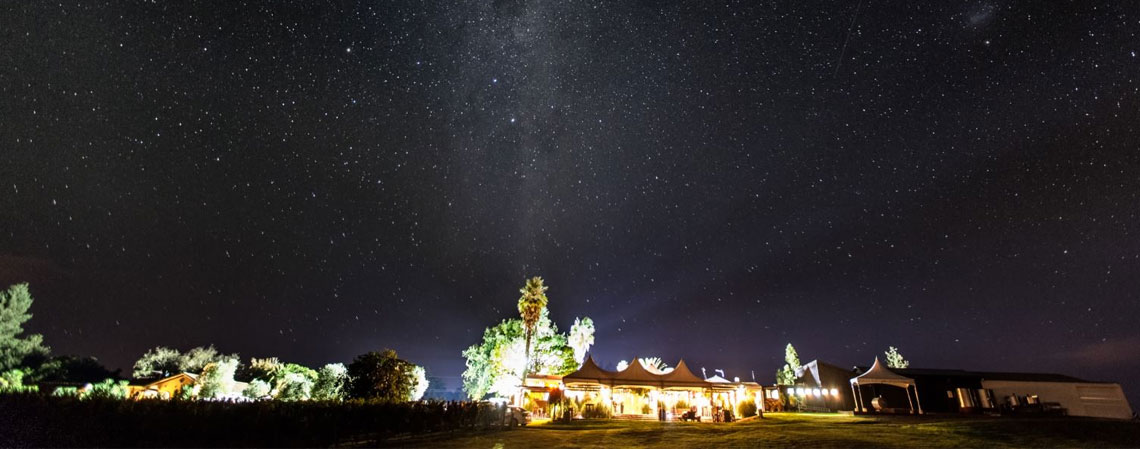 Winery venue lit up at night under a clear starry sky