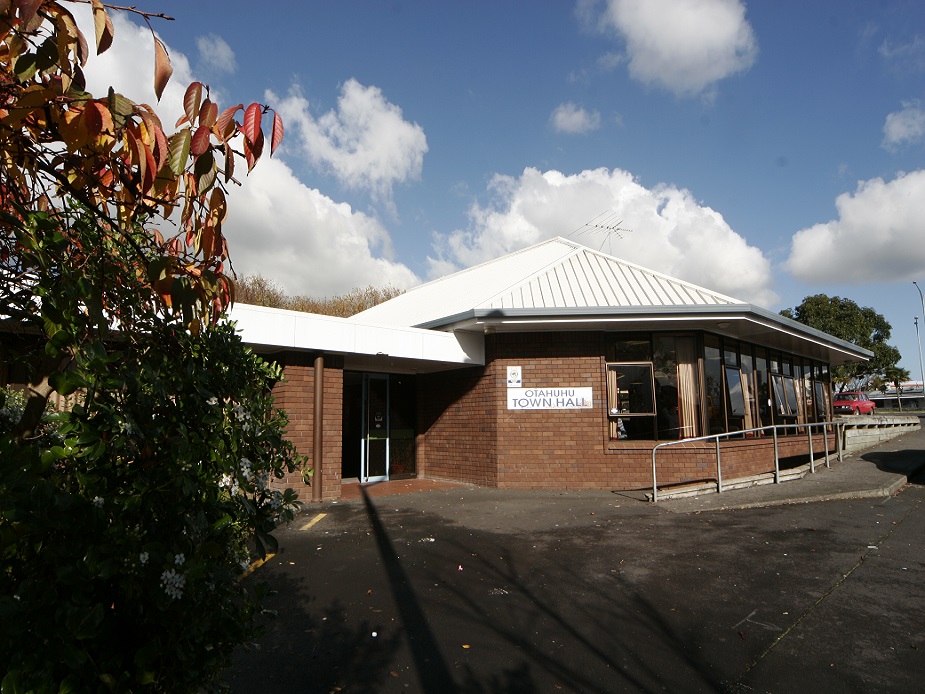 Single-storey brick community hall with white pitched roof and entry sign