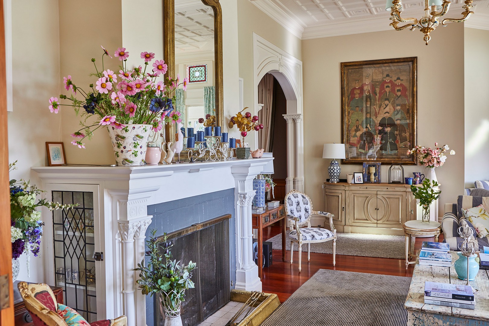 Heritage homestead interior lounge with ornate fireplace, flowers and period furnishings