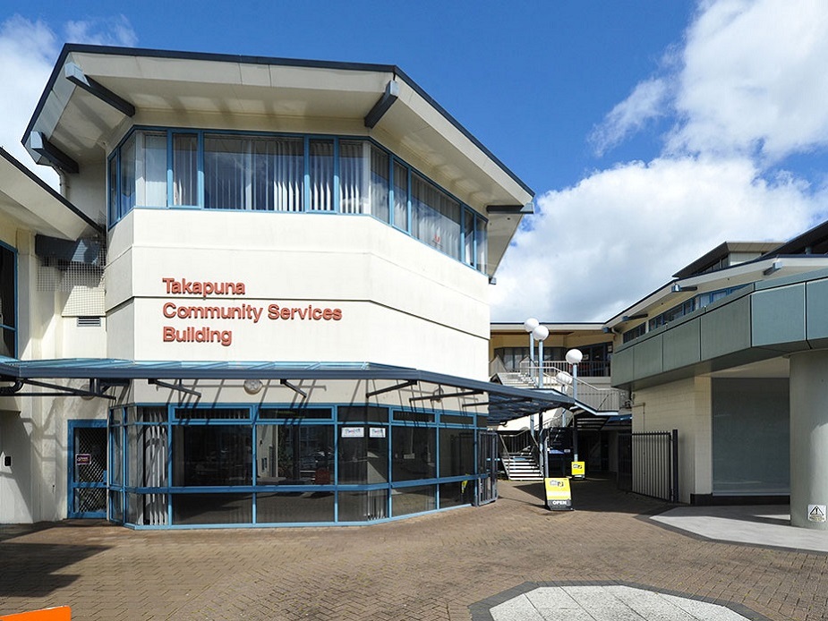 Two-storey community services building with signage, courtyard entrance, and covered walkway
