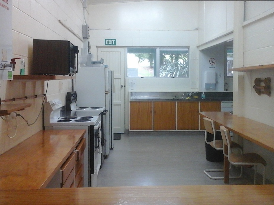 Community kitchen with timber benches, appliances and shelving