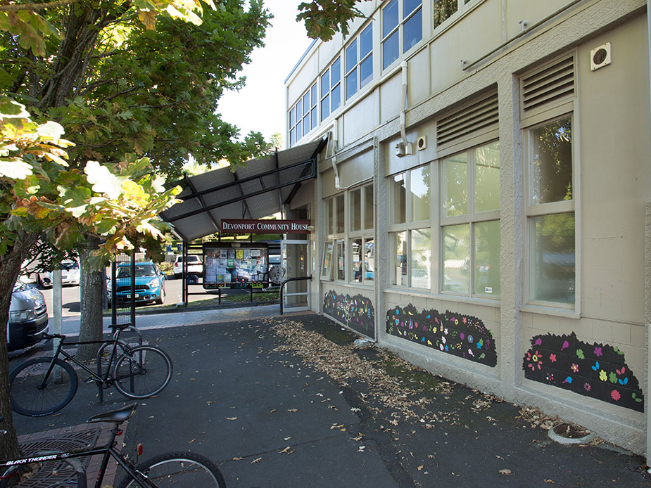 Community house exterior with entrance canopy, bikes and decorative window murals
