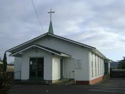 Plain white church building with cross on roof