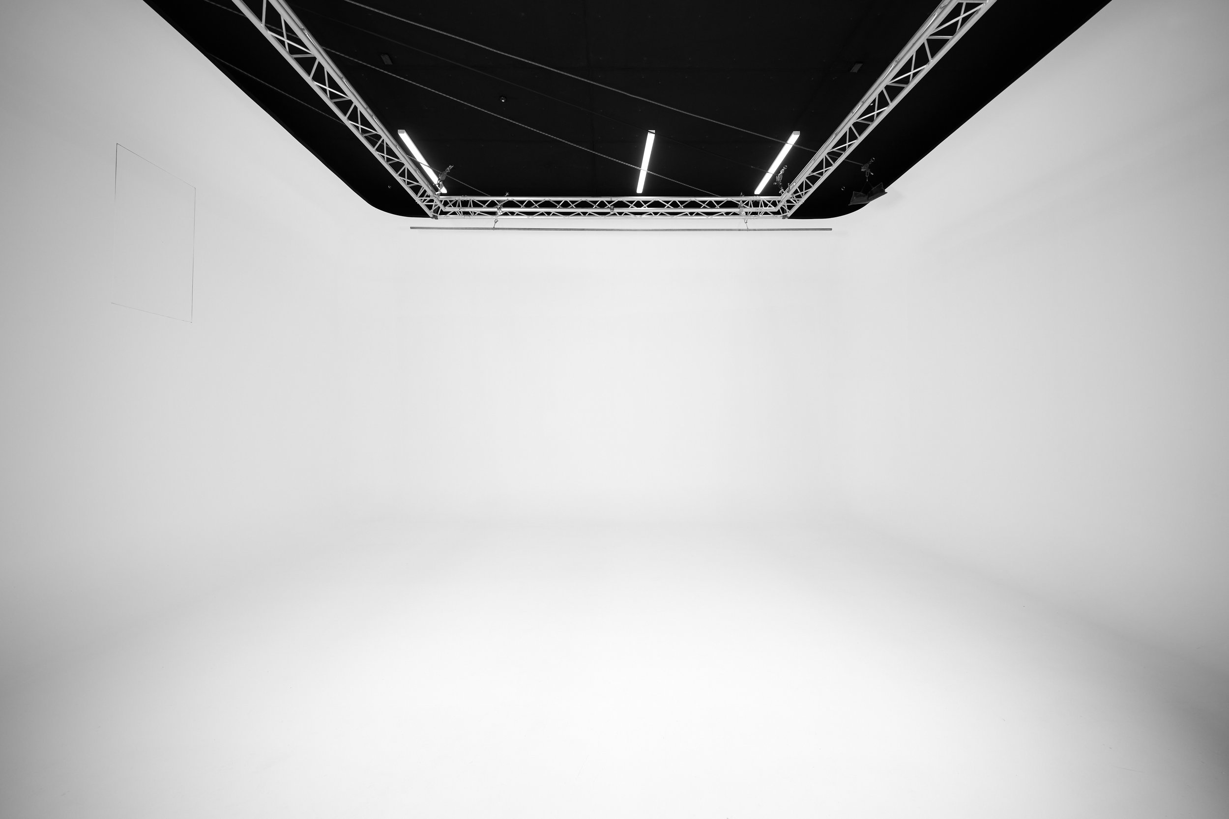 Empty white cyclorama studio with lighting truss overhead