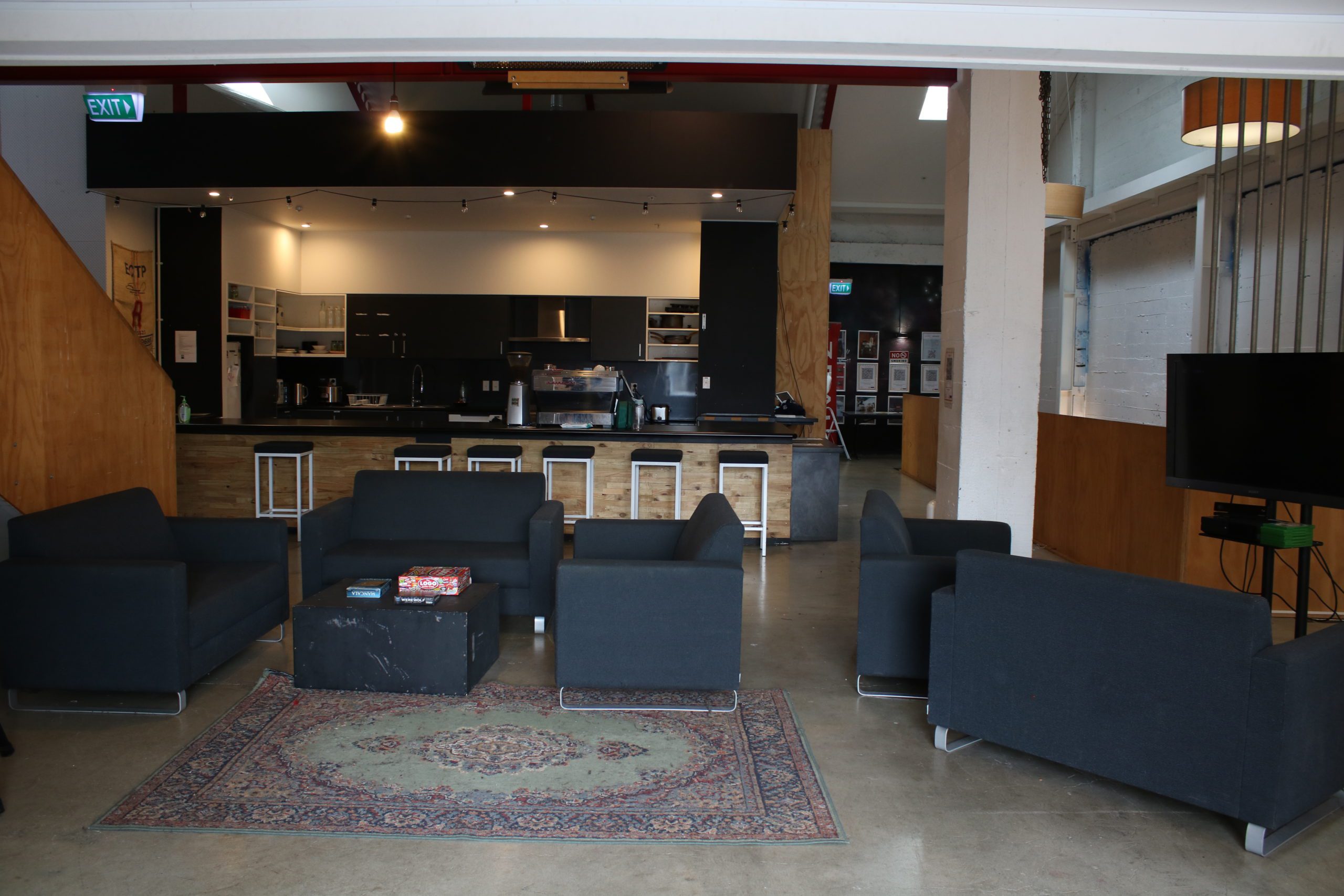 Open-plan interior with sofas, bar, and kitchen area