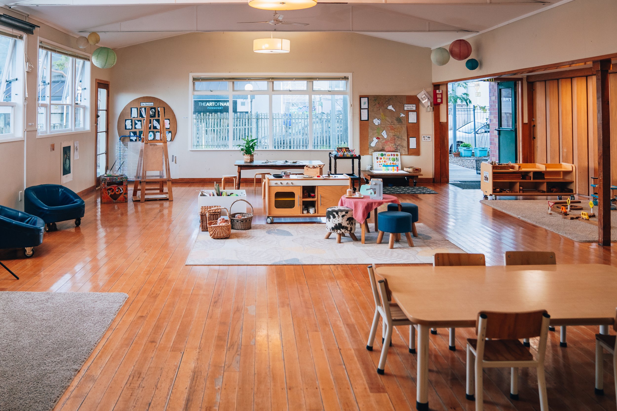 Church hall interior with timber floor, vaulted ceiling, and toy equipment set up for a playgroup