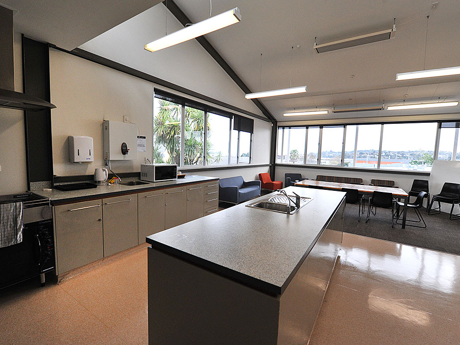 Open kitchen with island bench and seating area, large windows with views