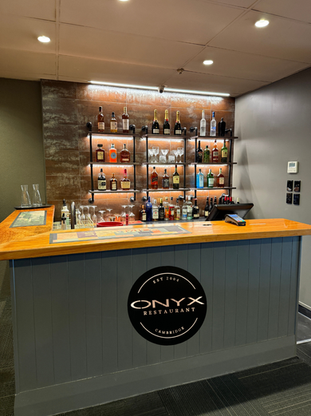 Bar counter with branded signage and shelved spirits display