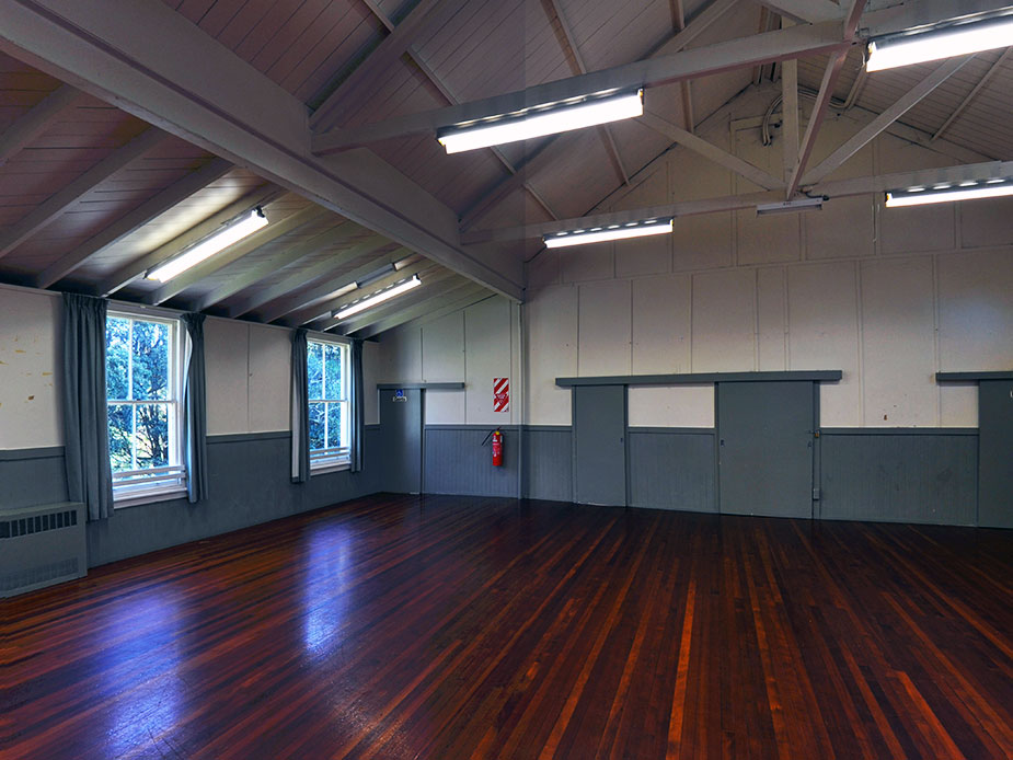 Empty hall with polished timber floor and vaulted ceiling with trusses