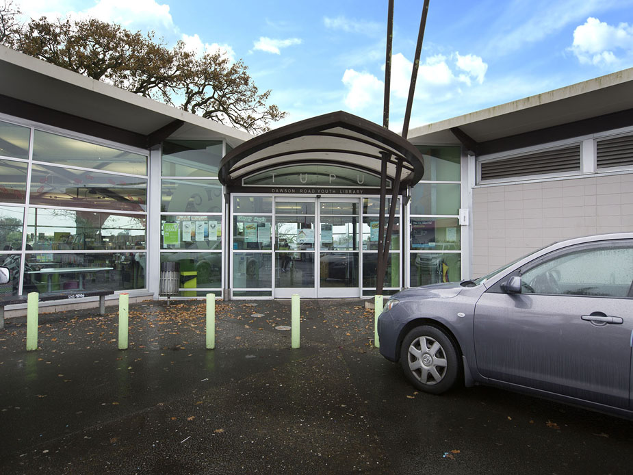 Low-rise library building entrance with glass frontage and covered entry