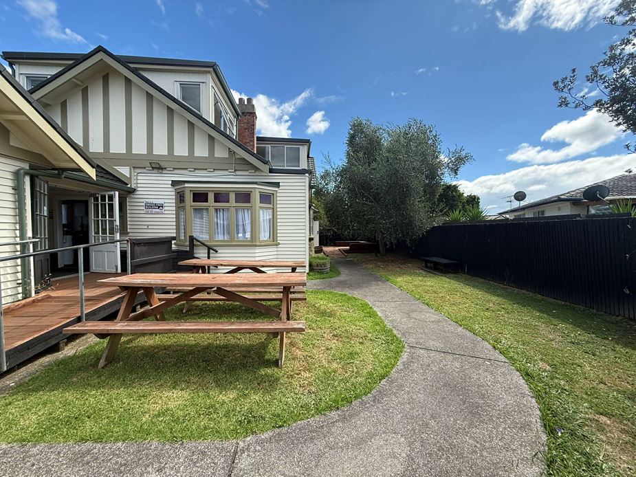 Side garden area with deck, picnic tables and timber fence