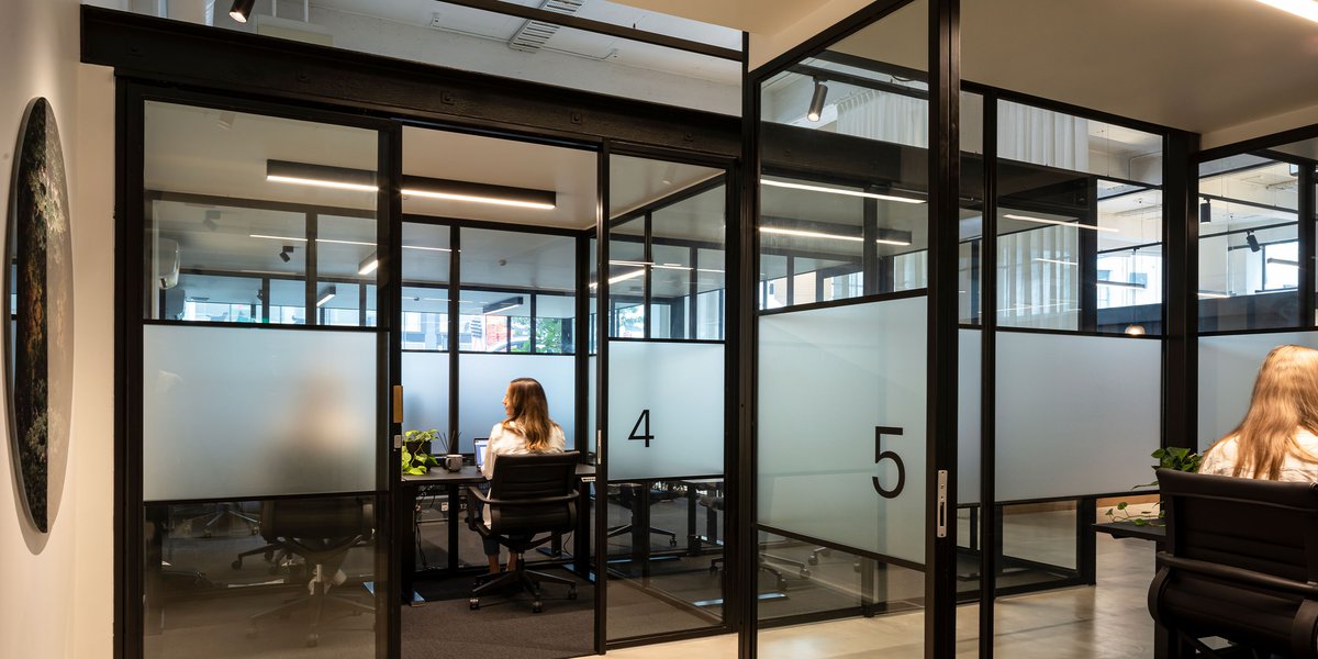 Glass-partitioned meeting rooms numbered four and five with people seated inside