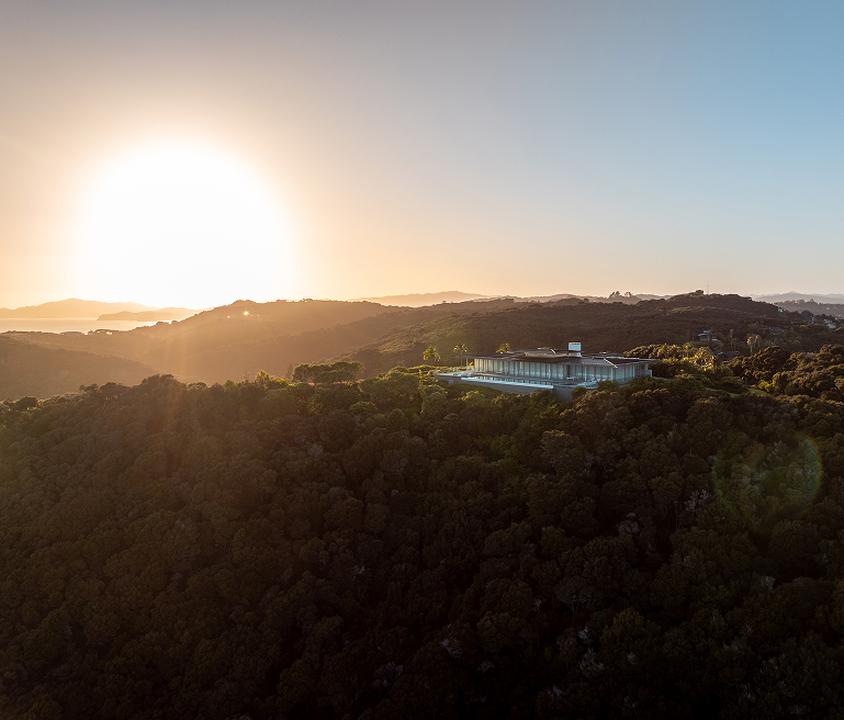 Aerial view of lodge amid dense bush at sunset