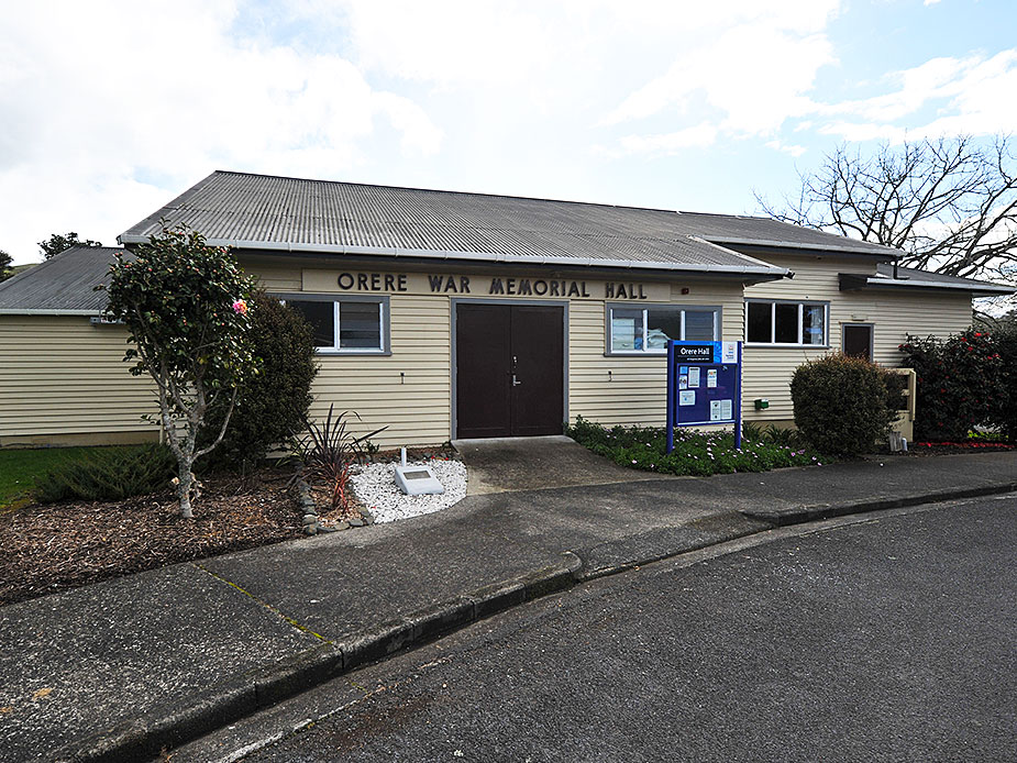 Single-storey weatherboard hall with corrugated roof and entrance garden