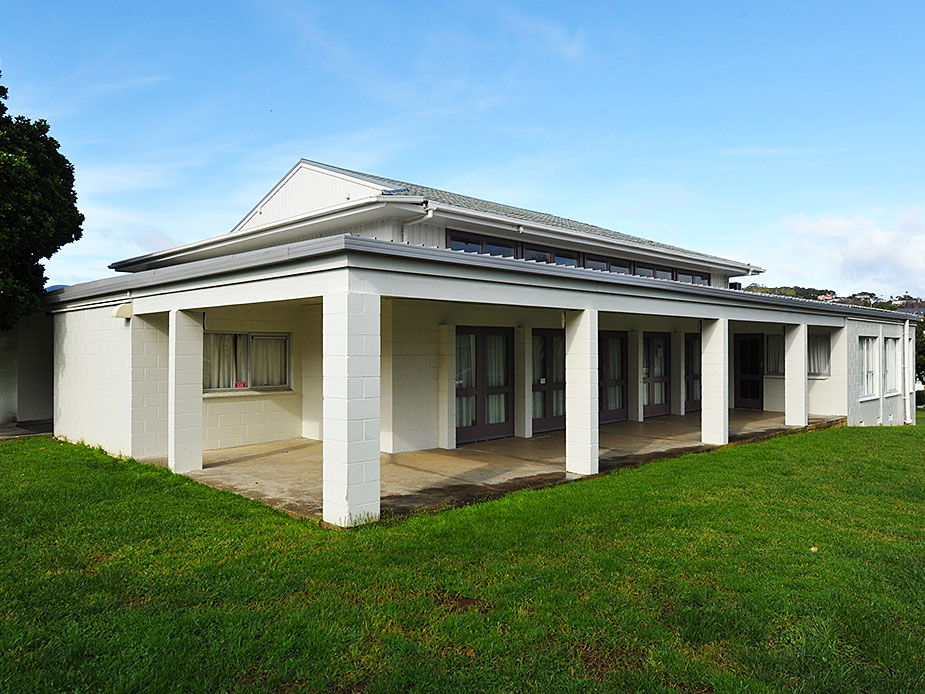 Single-storey rendered-block hall with covered verandah and lawn