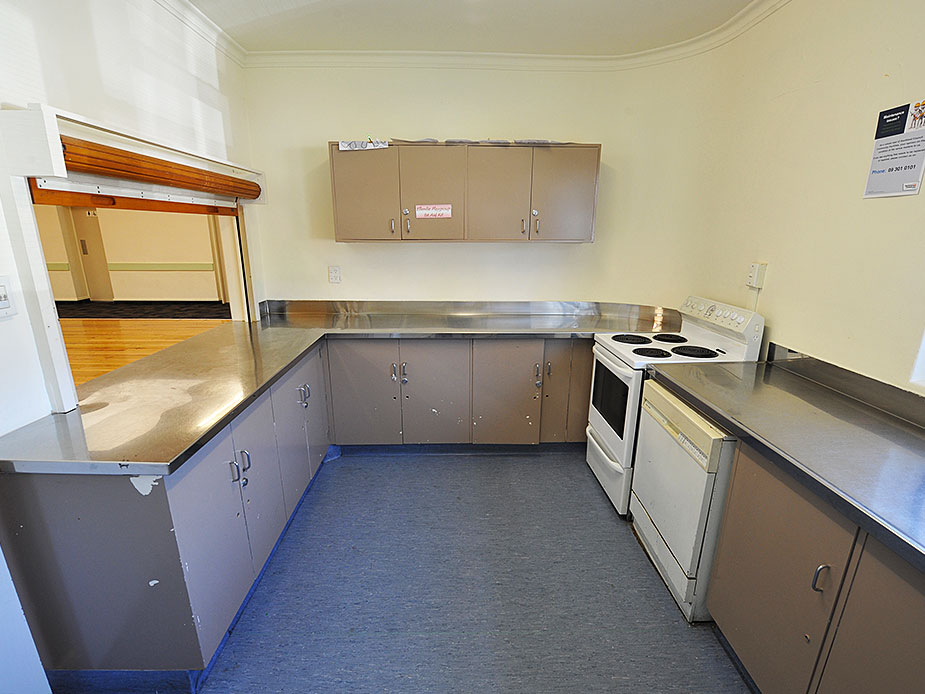 Community kitchen with stainless benches, oven and serving hatch