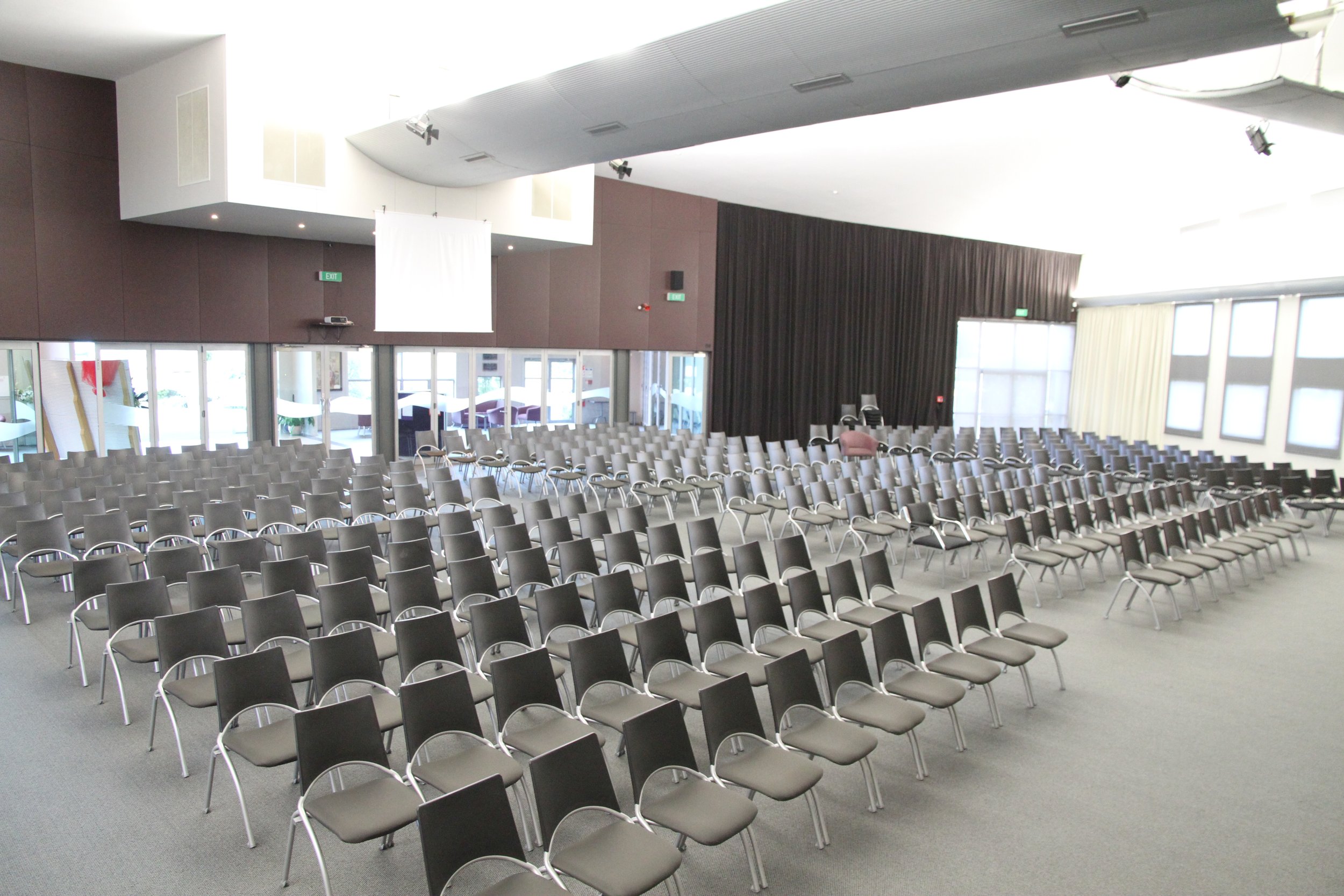 Large auditorium with rows of chairs and raised platform