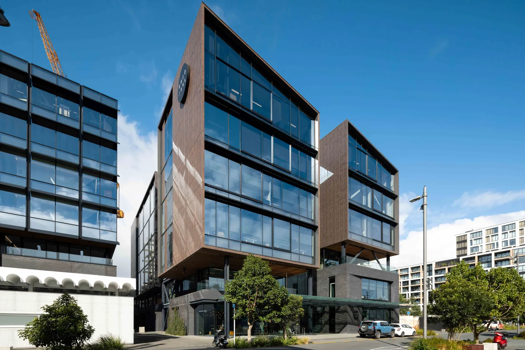 Multi-storey commercial building with timber and glass facade under blue sky