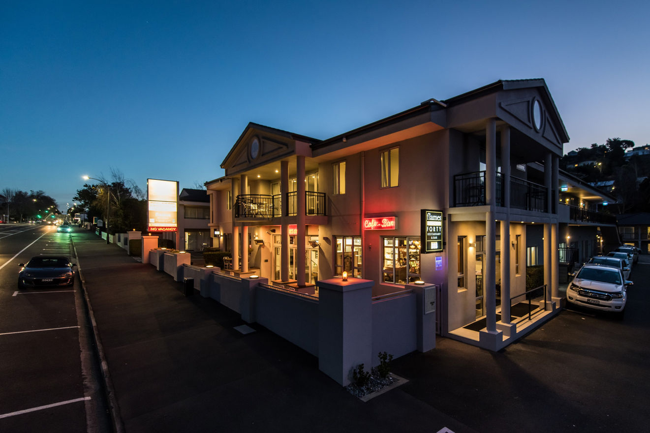 Two-storey motel building with balconies illuminated at night