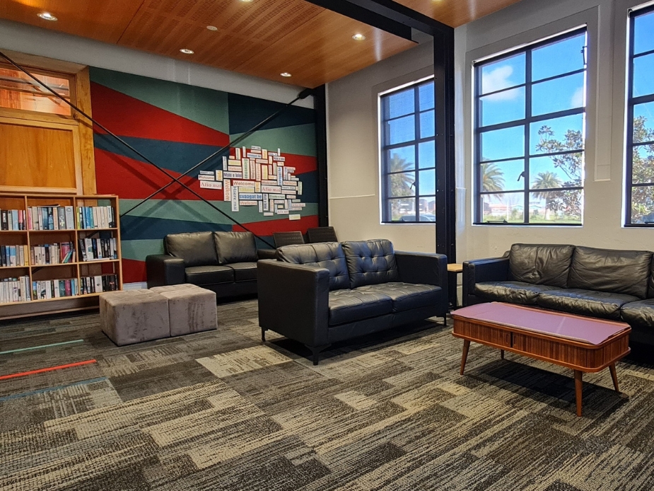 Lounge seating area with leather sofas, colourful mural, and bookshelves