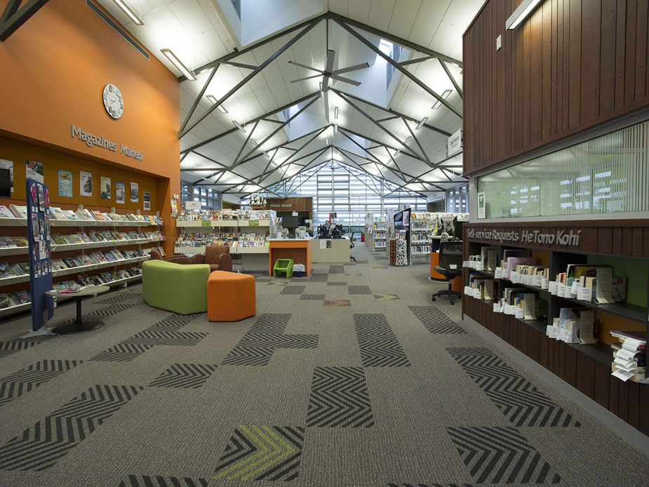 Open library interior with high vaulted ceiling, colourful seating and bookshelves