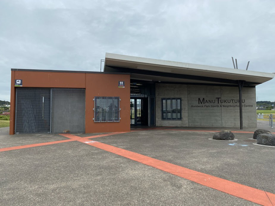 Single-storey sports and community centre with terracotta and concrete facade