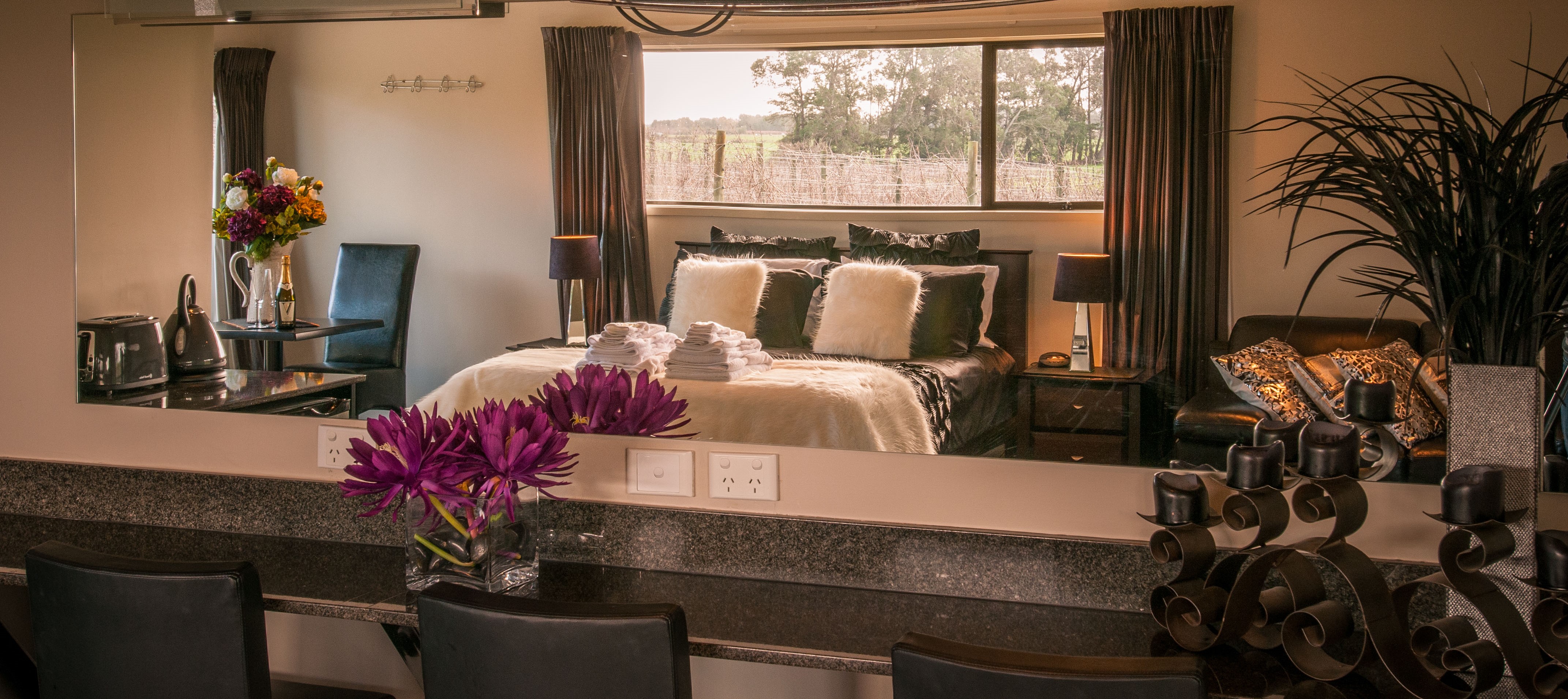 Studio room with bed, kitchenette and vineyard view through window