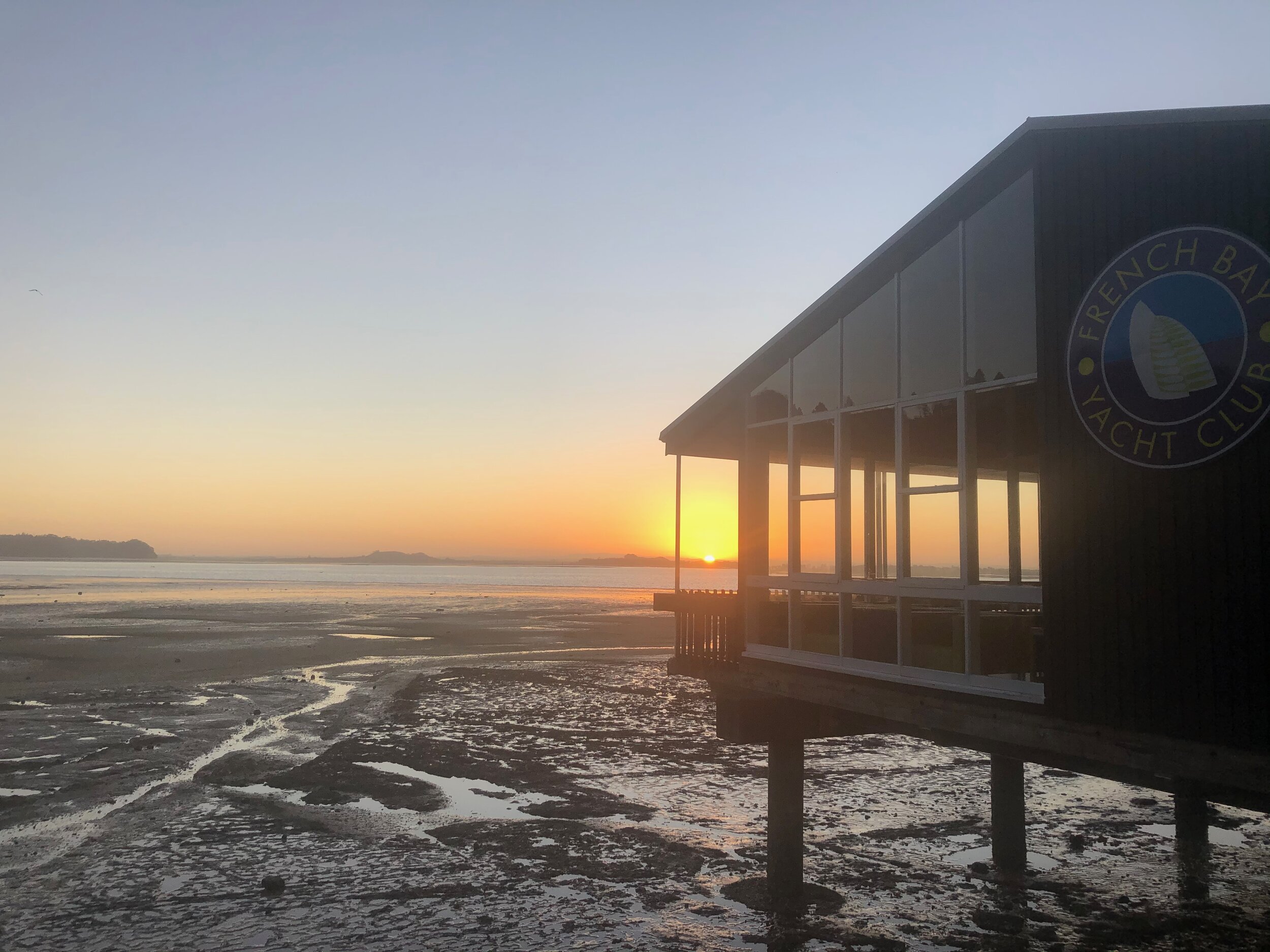 Waterfront building at sunrise with tidal flats exposed