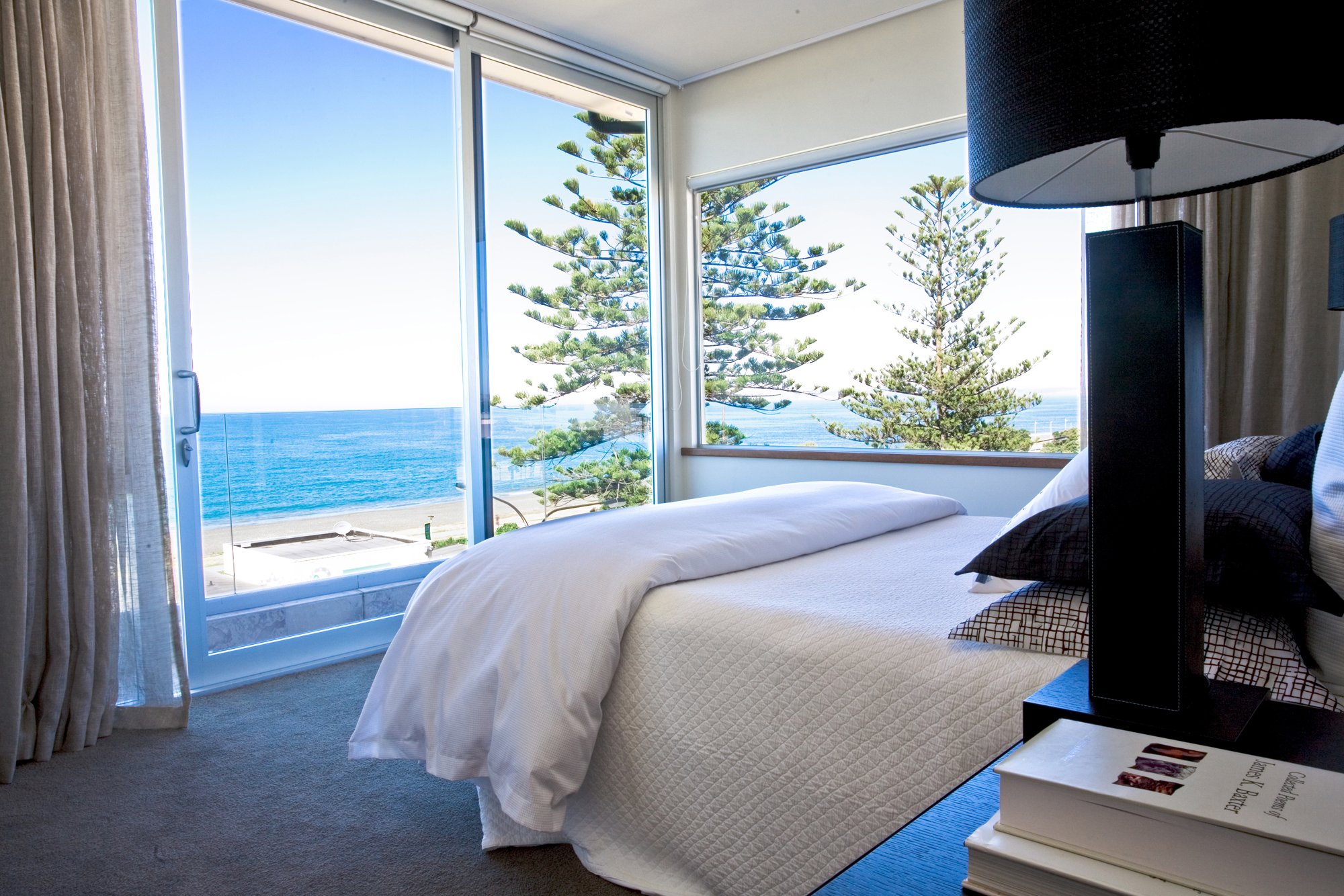 Hotel bedroom with dark timber headboard wall and balcony door