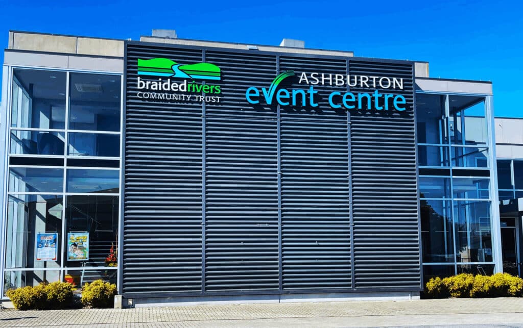 Modern event centre exterior in daylight with dark louvred facade and glazed sections