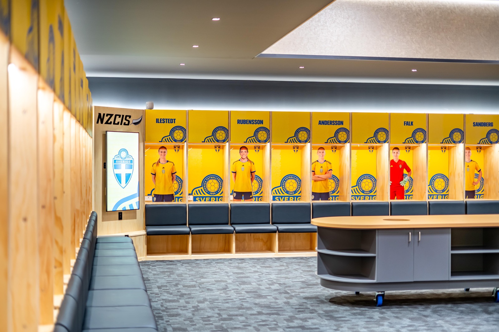 Sports changing room with lockers, player photos and a central briefing table