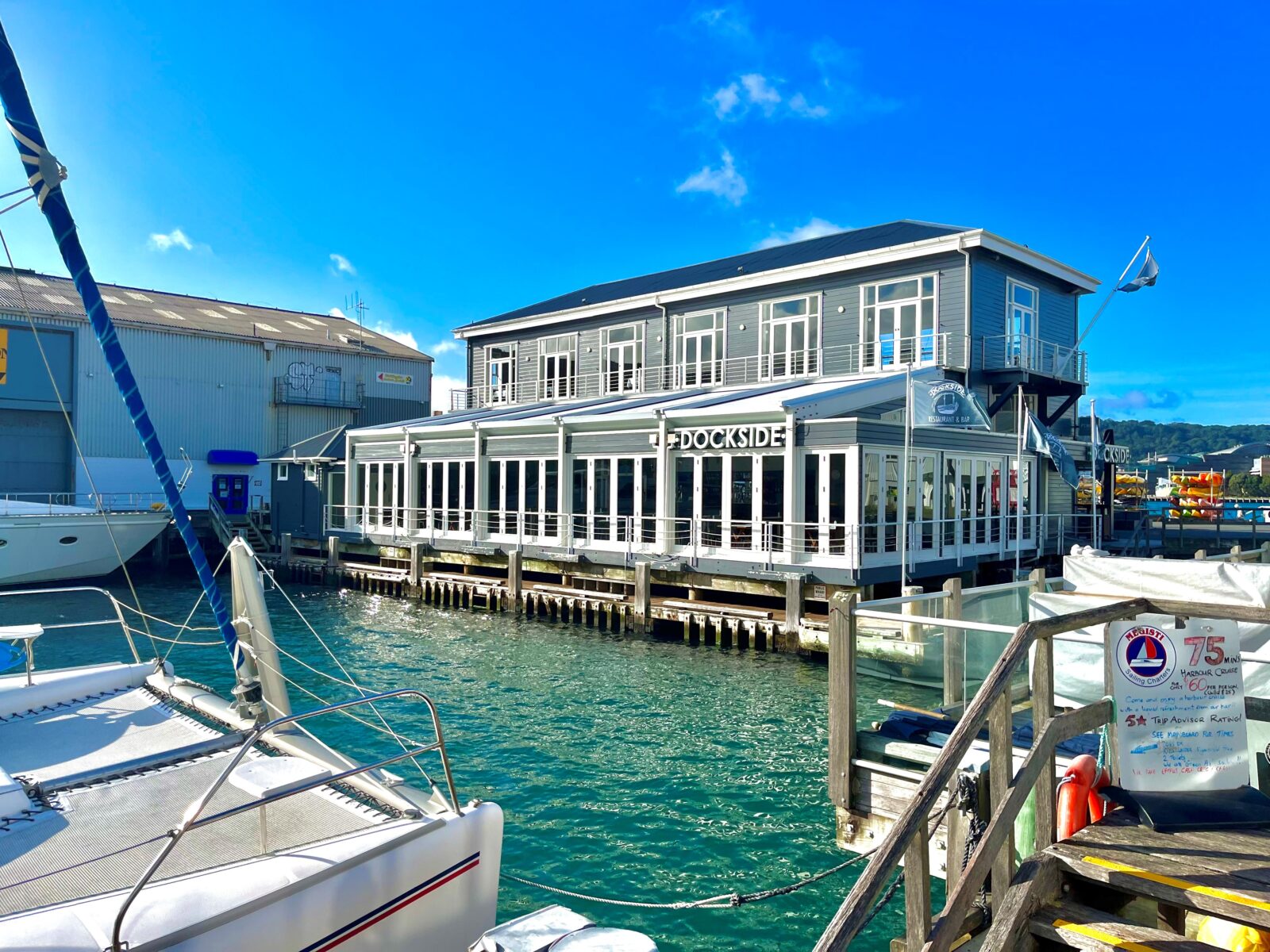 Dockside restaurant building over the water with boats moored alongside