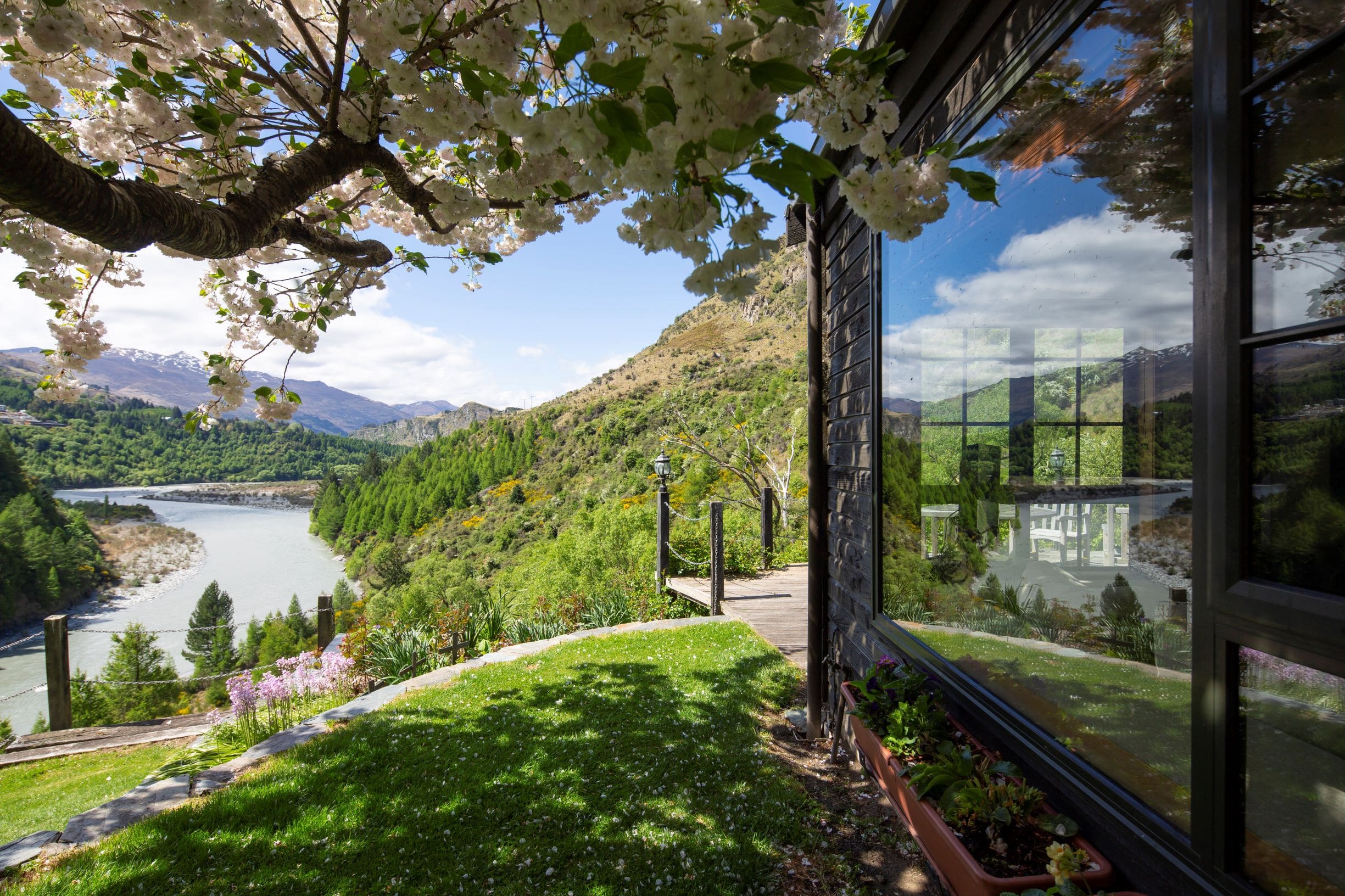 Garden terrace with a blossom tree overhanging the building and views to the river and mountains