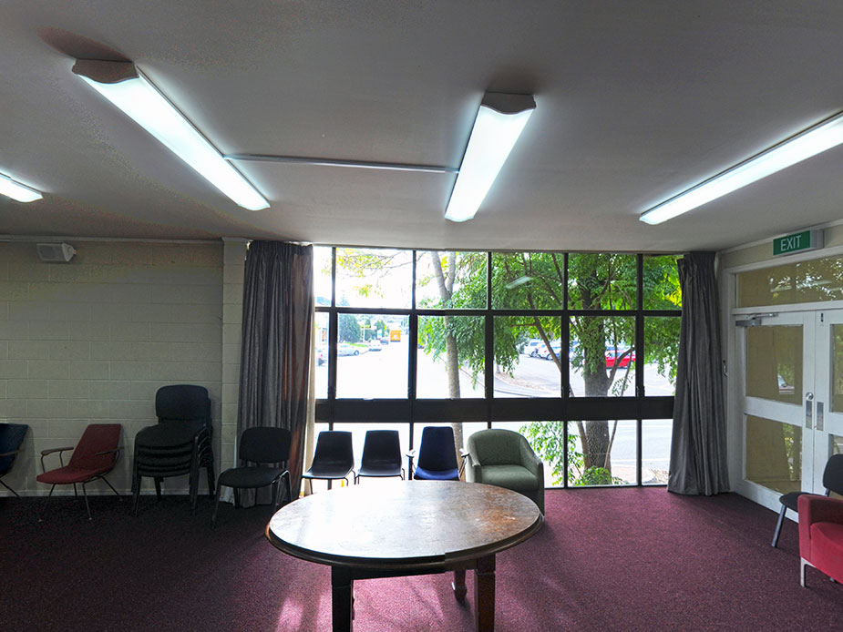 Hall interior with round table, chairs and large windows overlooking trees