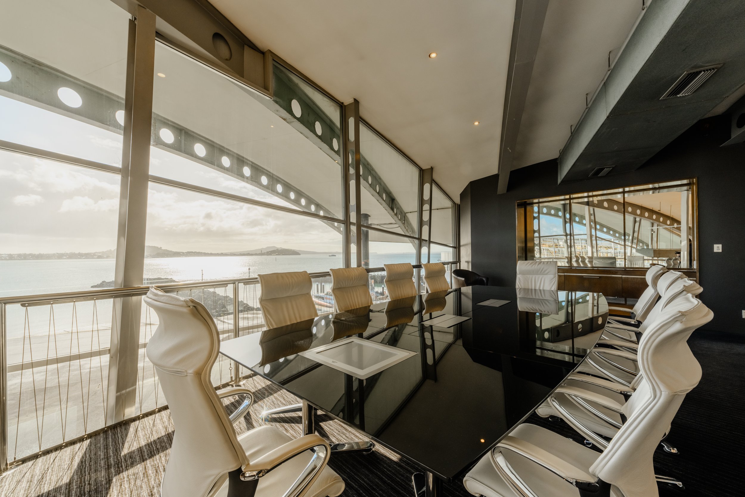 Upper-level meeting room with floor-to-ceiling harbour views and executive chairs