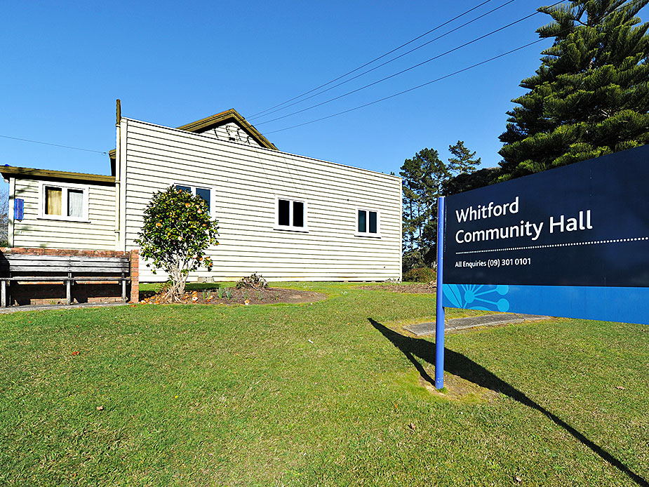 White weatherboard community hall with signage and lawn