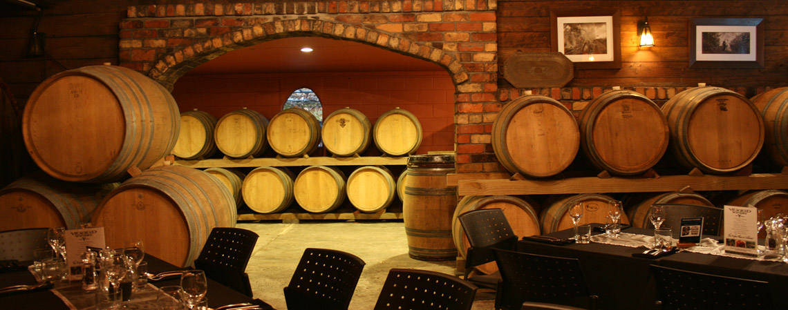 Wine barrel cellar dining room with exposed brick and arched wall
