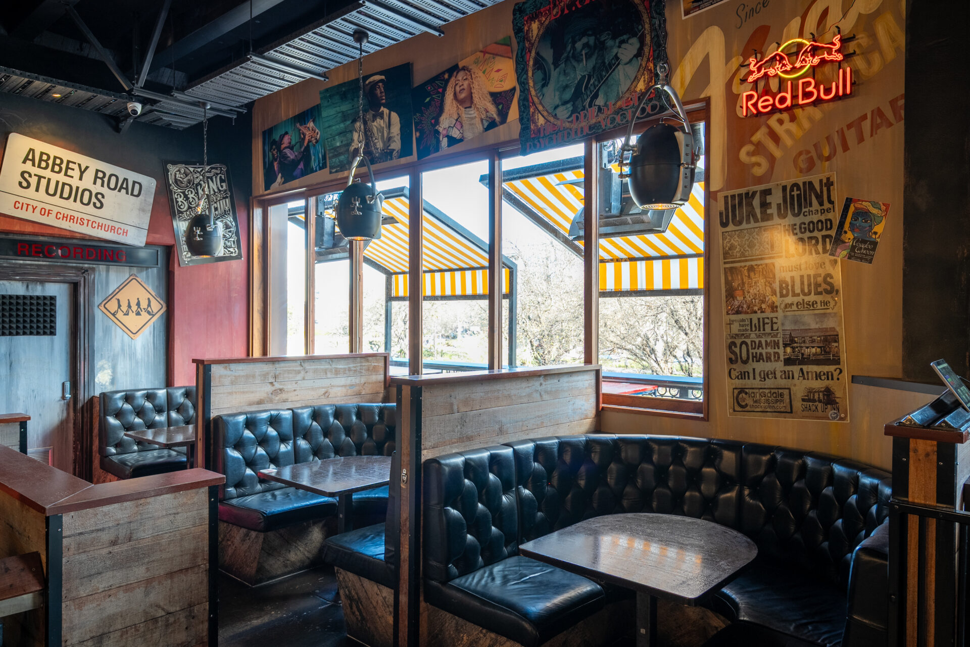 Bar seating area with music posters, vintage signs and leather banquette booths