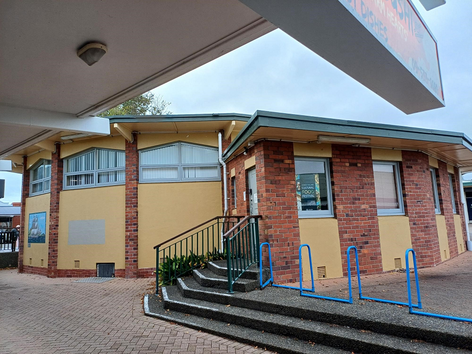 Brick building exterior with steps, handrails and side access door
